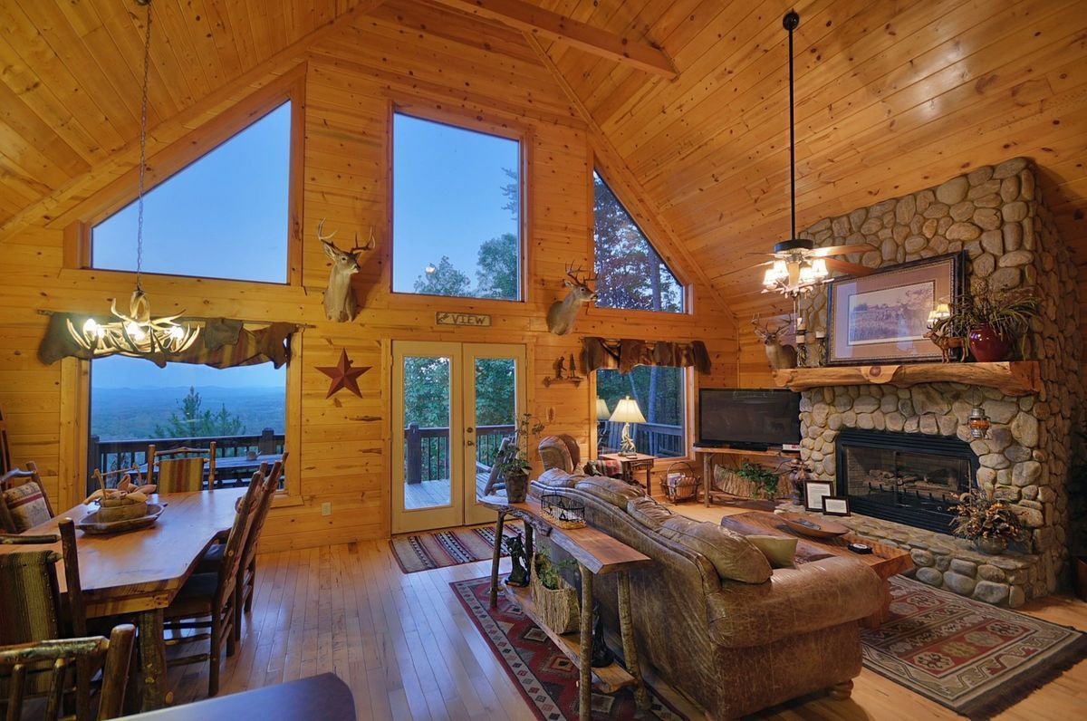 This Smoky Mountain cabin offers an open, cozy living area with floor-to-ceiling views, which affords beautiful views of the mountains and forests.